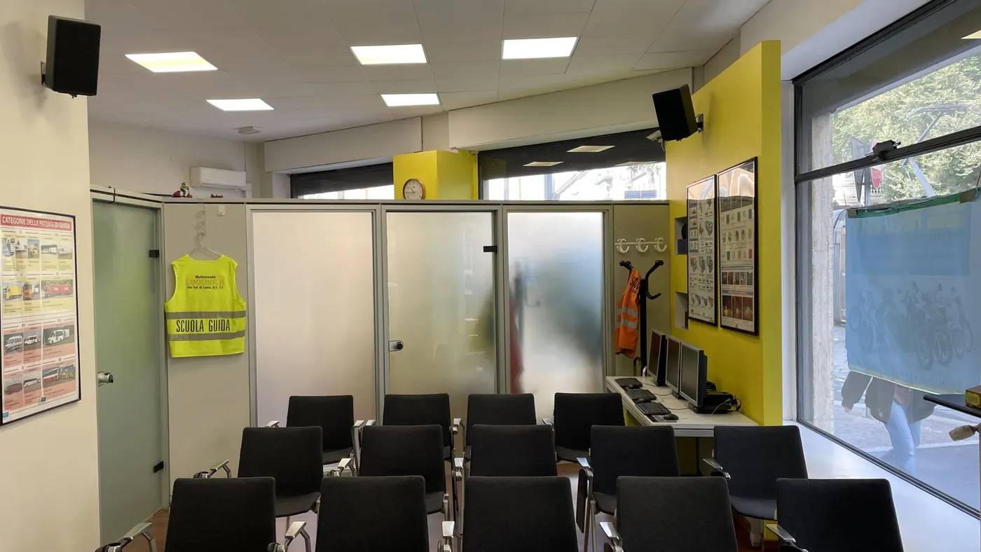 L’aula di teoria con le sedie nere e i cartelli alle pareti