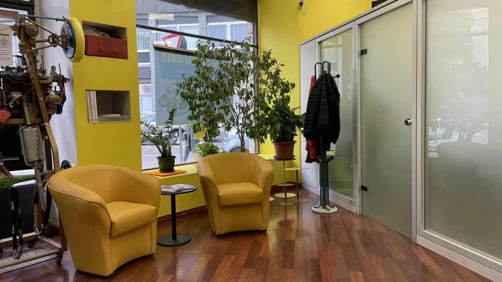 La sala d’attesa con le poltrone gialle e le piante